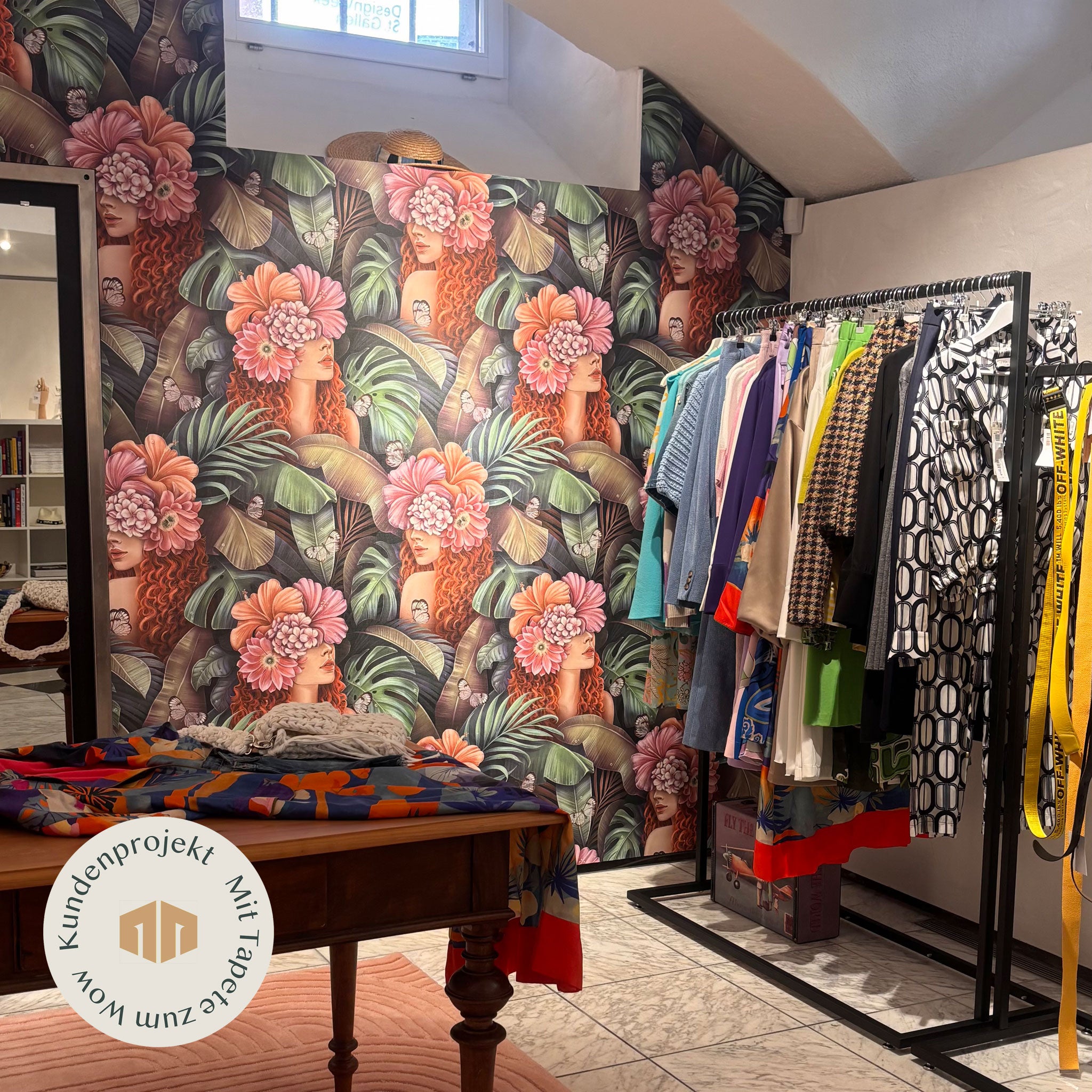 Edle Boutique mit farbiger Tapete in grün-rosa Tönen